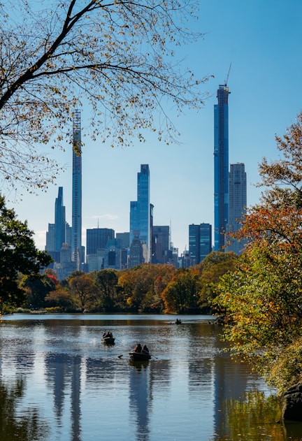 body of water near trees and high rise buildings during daytime