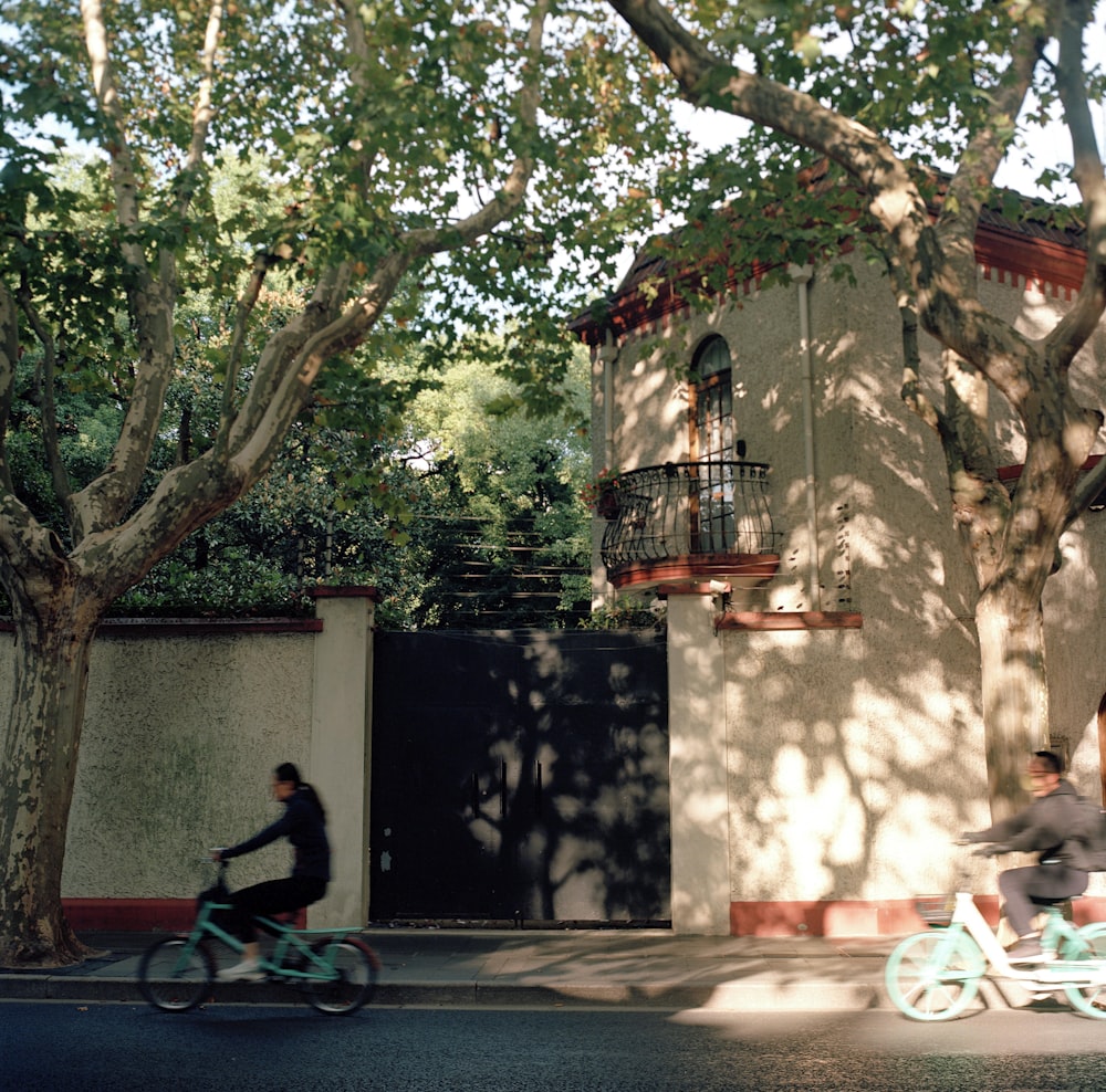 man in red shirt riding bicycle near green trees during daytime