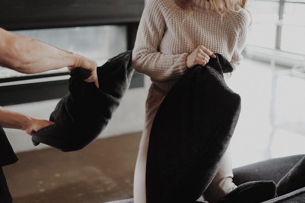 woman in white sweater and black pants sitting on white chair