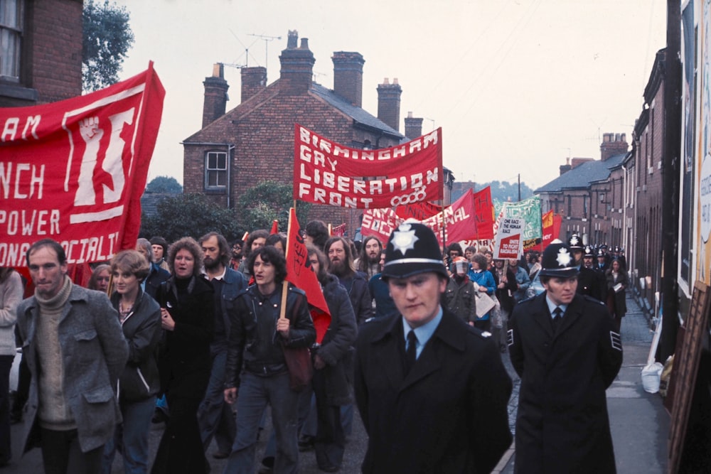 people in black suit standing near red and white flag during daytime