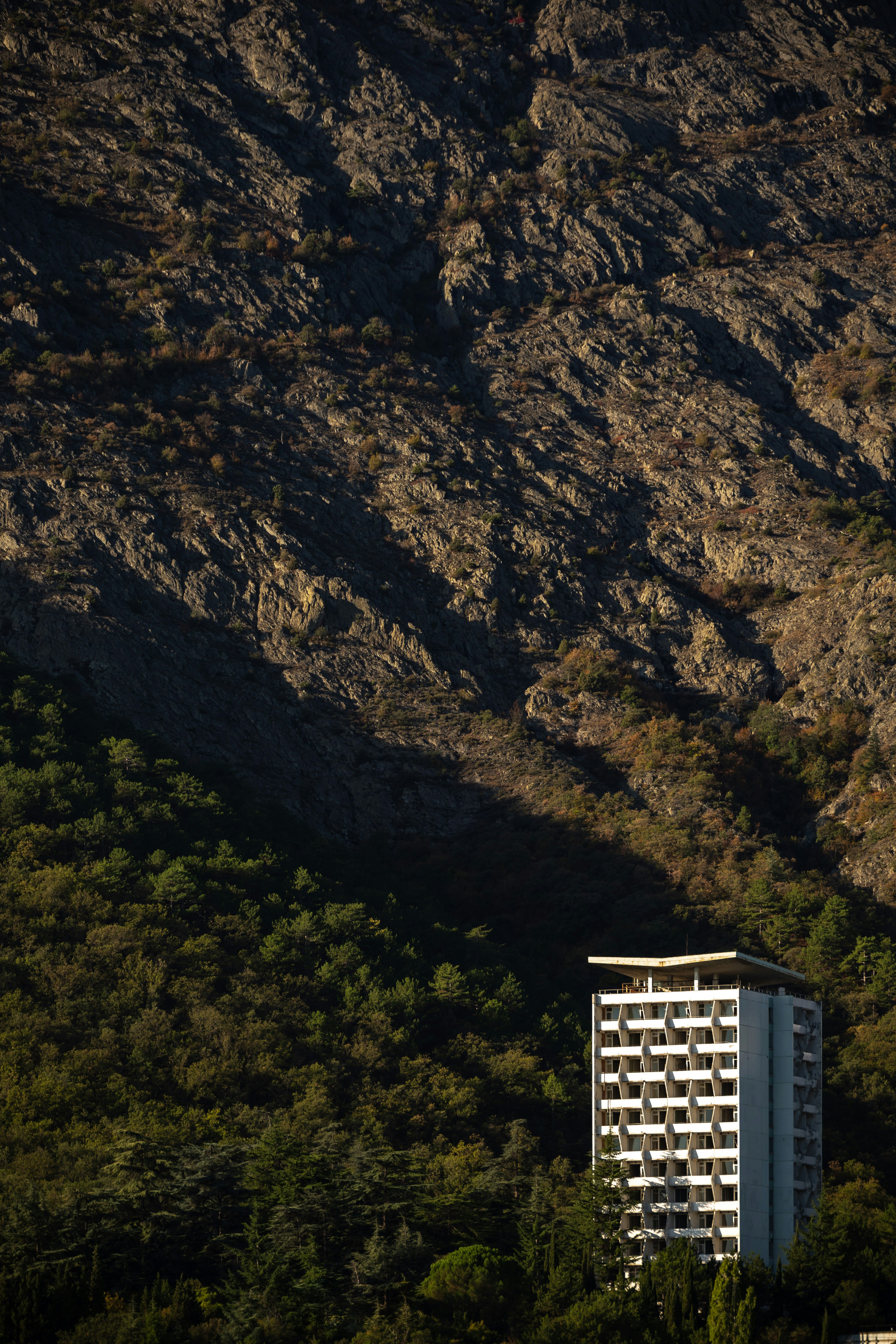 Edificio in cemento bianco e nero vicino alla montagna rocciosa marrone durante il giorno