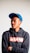 man in black and orange pullover hoodie wearing blue cap