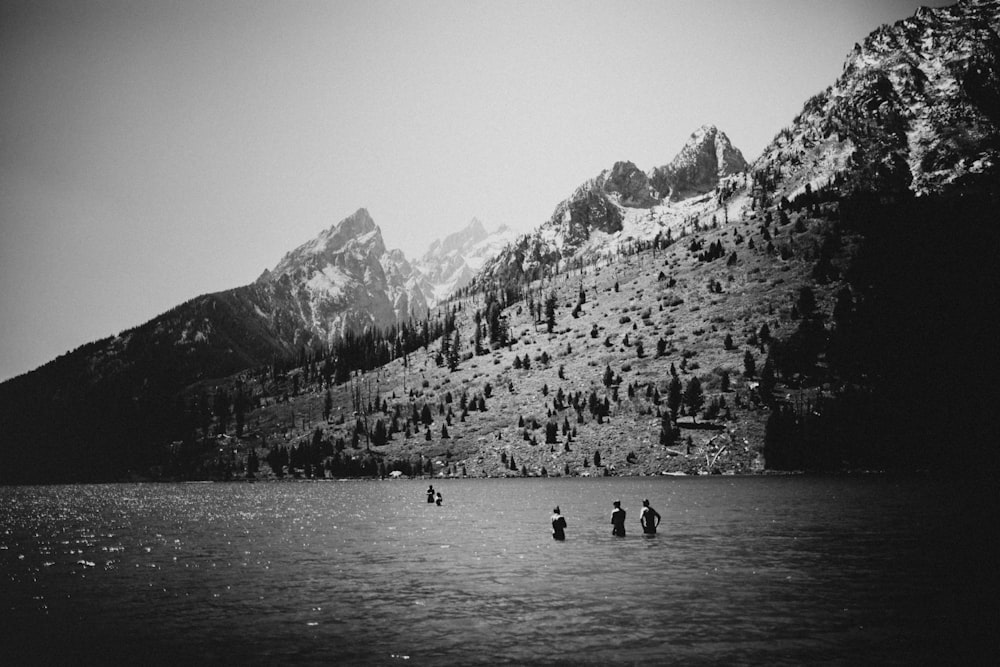 grayscale photo of people on beach