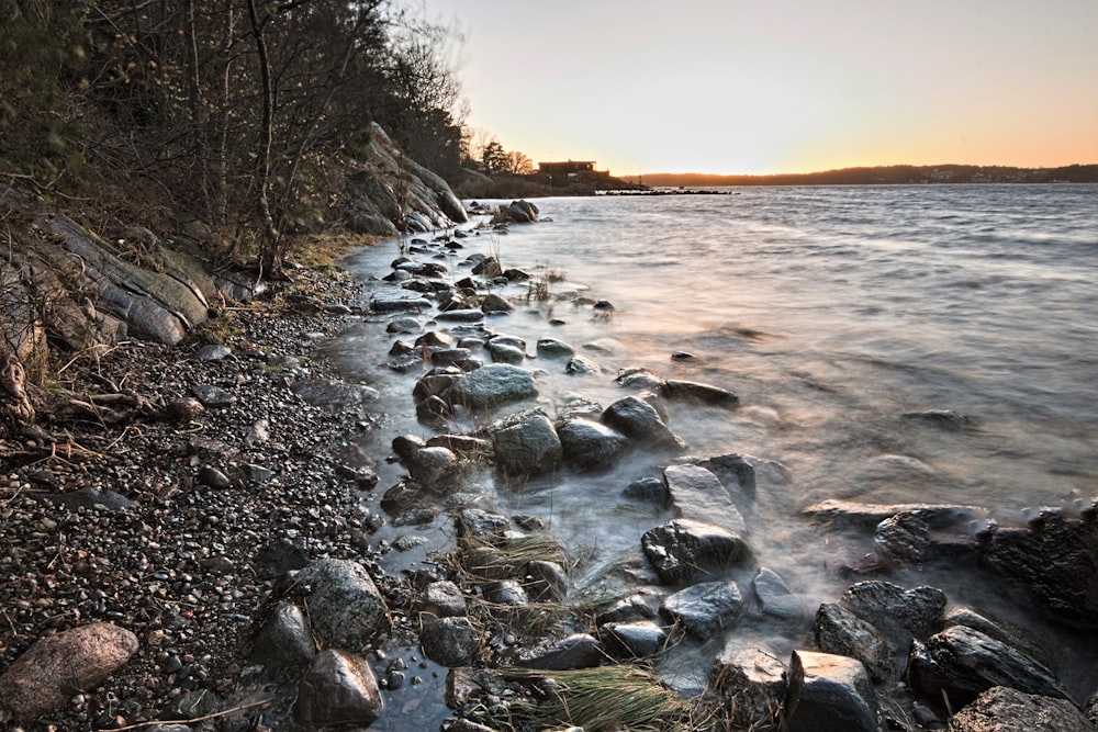 Rivage rocheux avec des rochers sur le côté au coucher du soleil