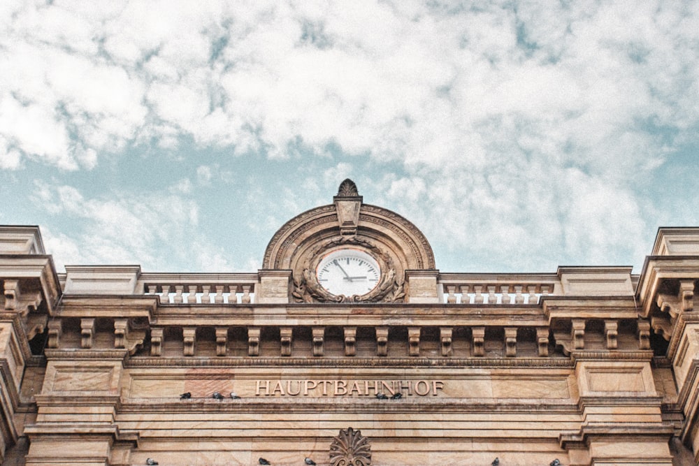 low angle photography of brown concrete building under white clouds during daytime