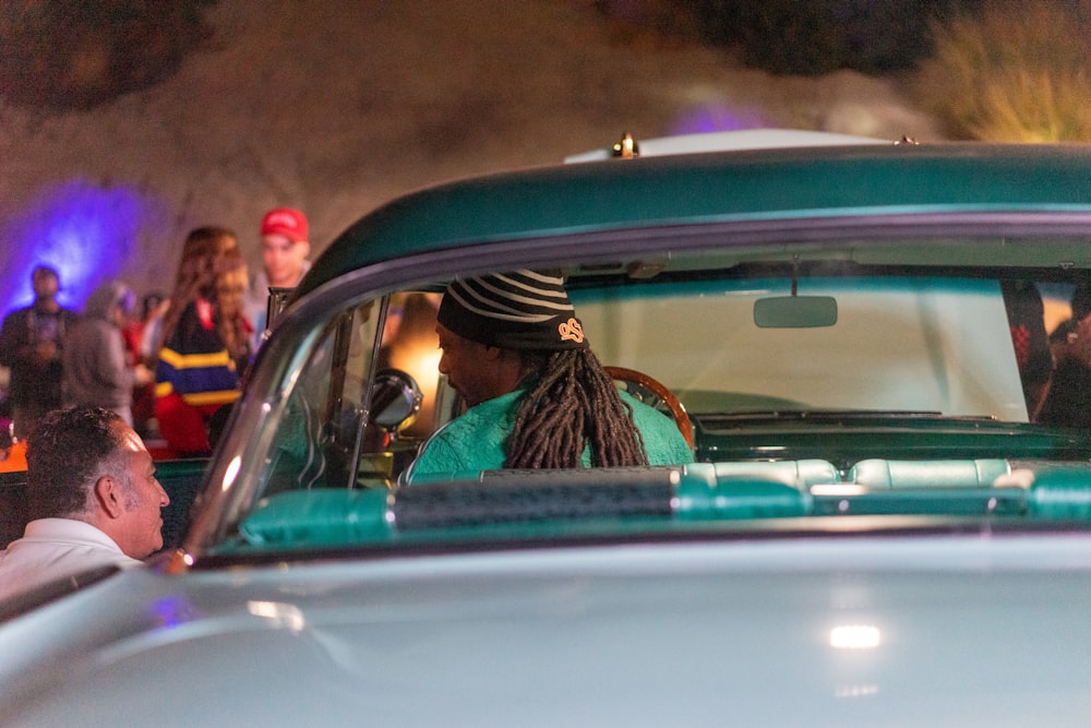 man in green and black plaid shirt driving car