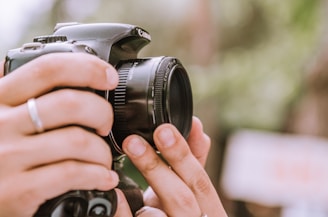 A close-up of a photographer adjusting their camera in a picturesque outdoor setting.