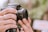 A close-up of a photographer adjusting a DSLR camera lens in natural light.