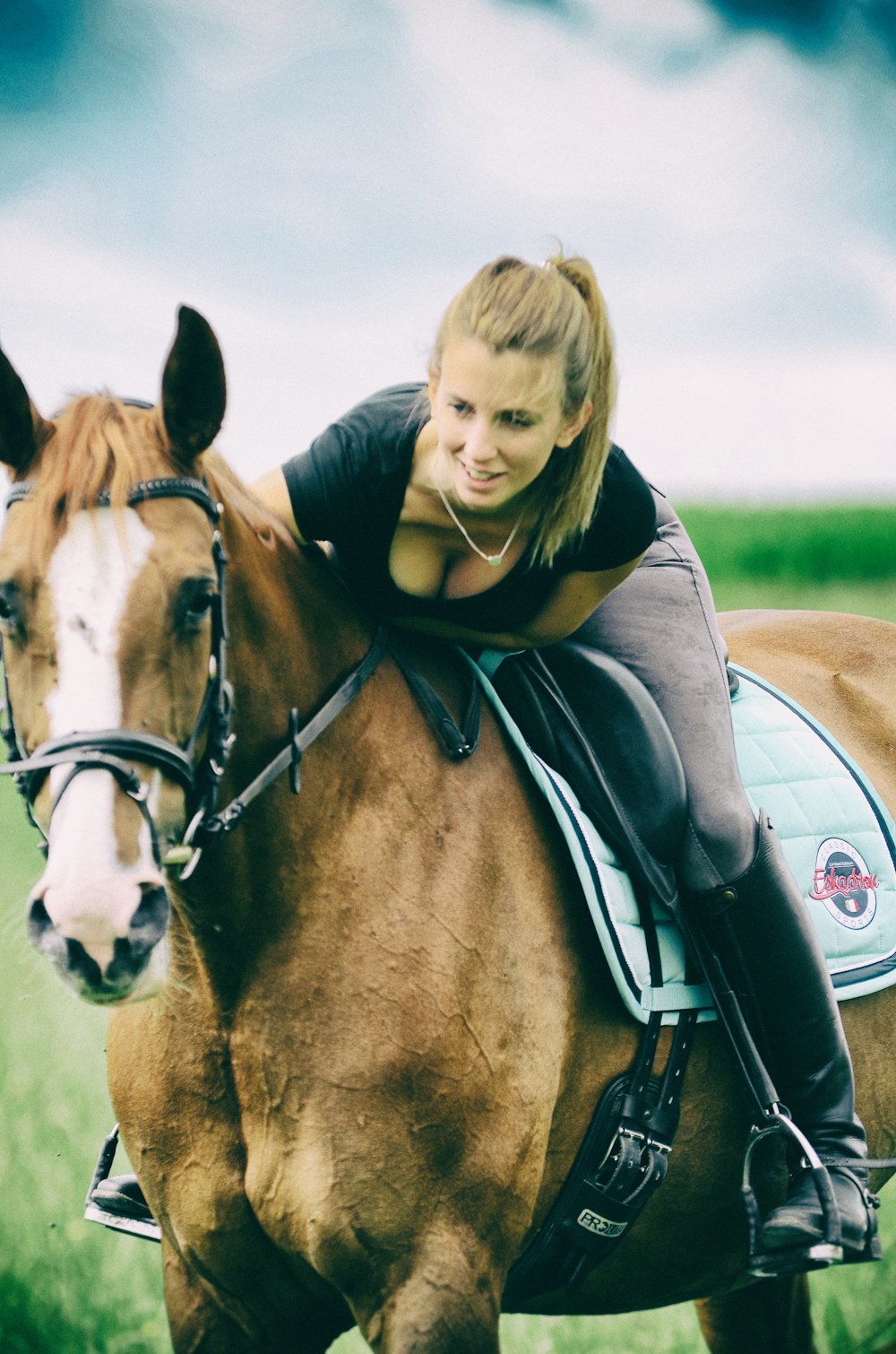 girl in black and white jacket riding on brown horse during daytime