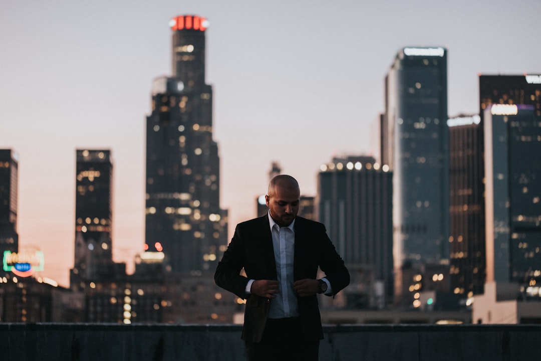 man in black suit standing on top of building during daytime