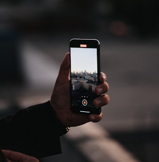 person holding black iphone 4