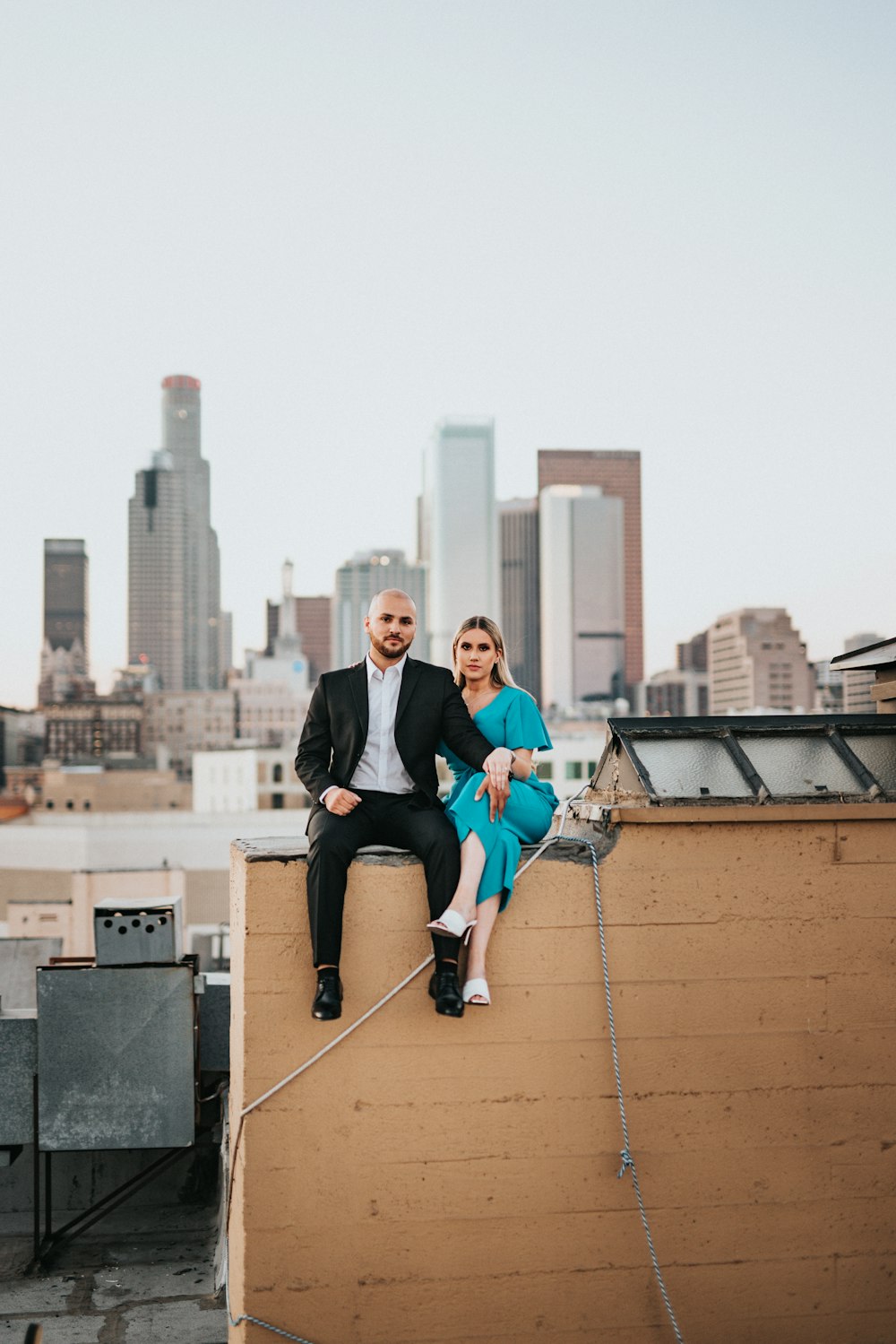 man in black jacket sitting on top of building during daytime