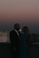 Evening shot of a couple dressed in Lumina Apparel, sharing a quiet moment on a rooftop terrace.