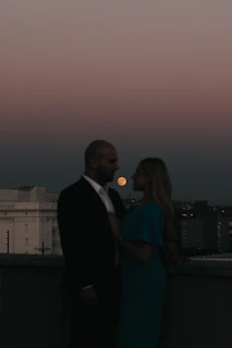 Evening shot of a couple dressed in Lumina Apparel, sharing a quiet moment on a rooftop terrace.