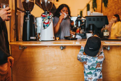 woman in white and blue floral dress standing beside woman in black hat