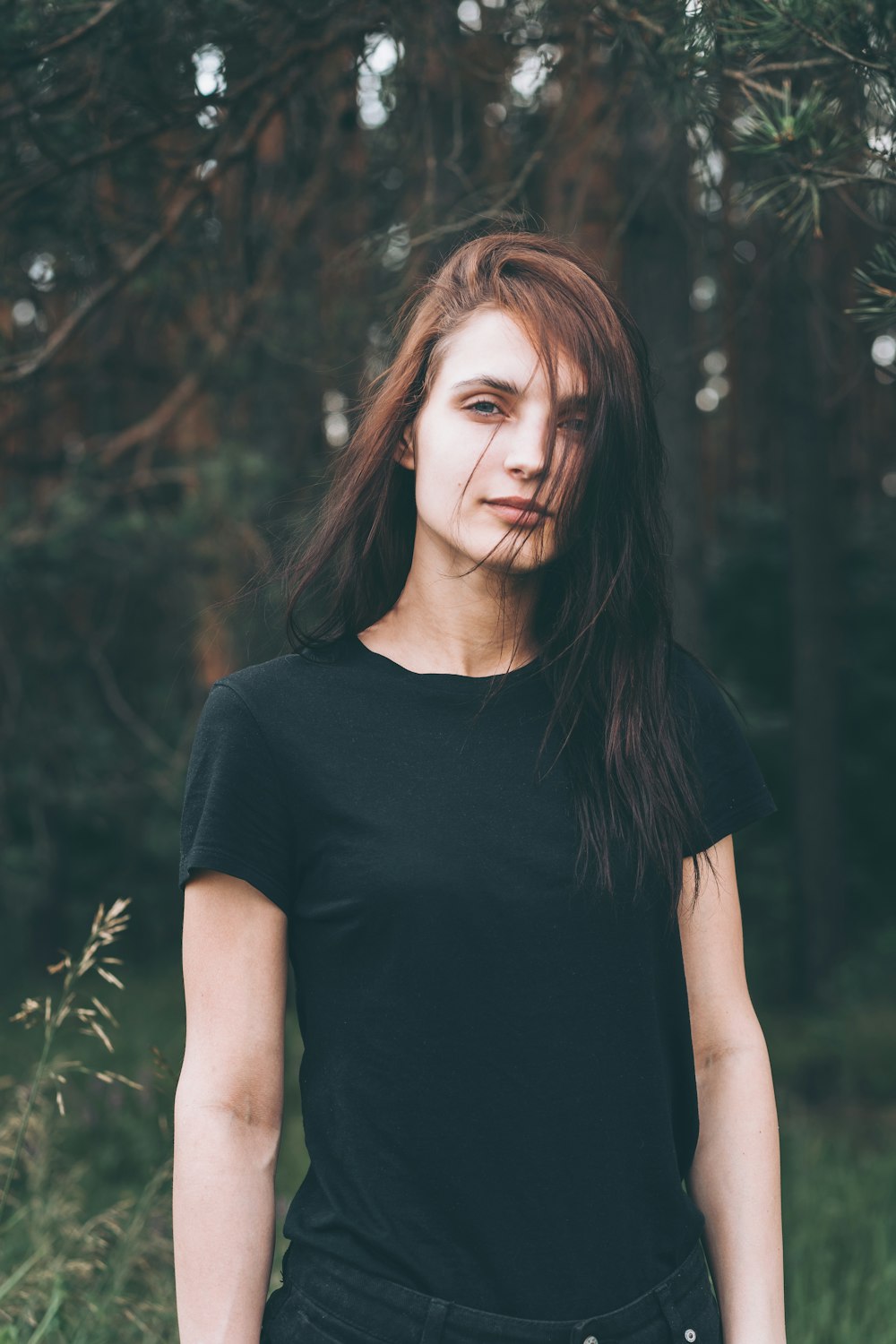 woman in black crew neck t-shirt standing near green plants during daytime