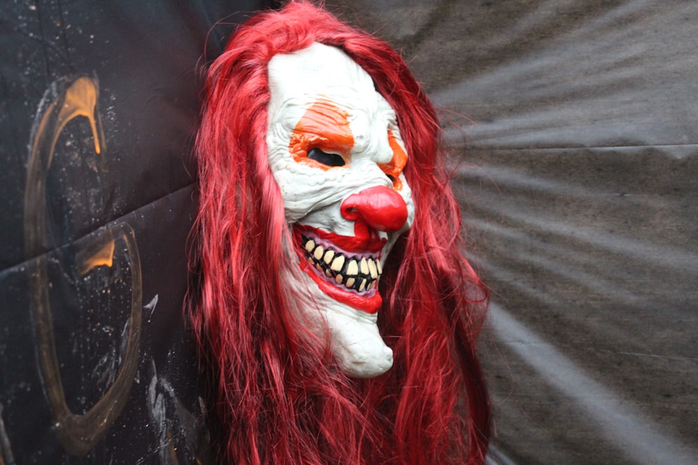 red haired woman with white and red face mask