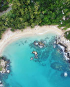 an aerial view of a sandy beach and blue water