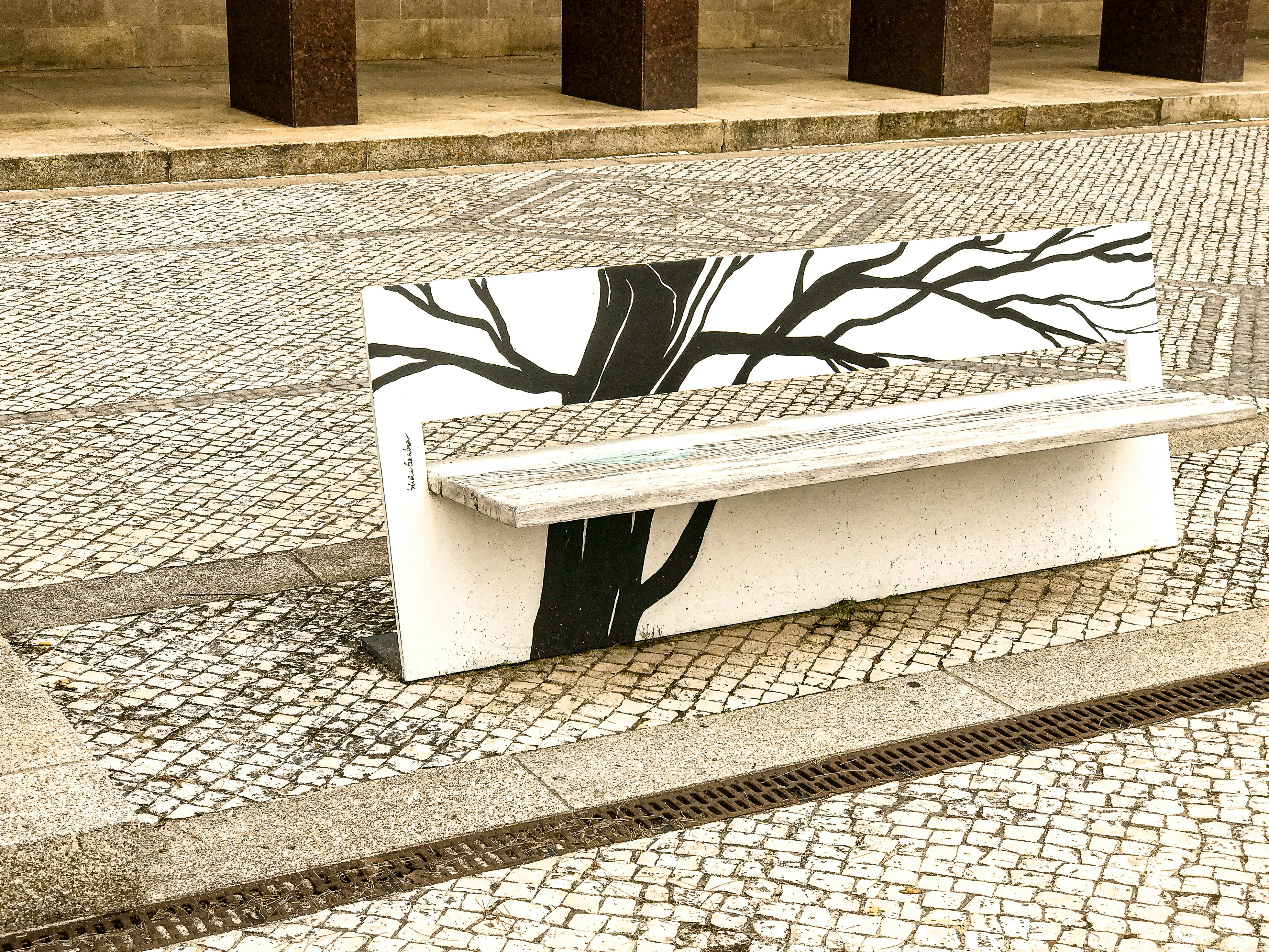 white and black bench on gray concrete floor