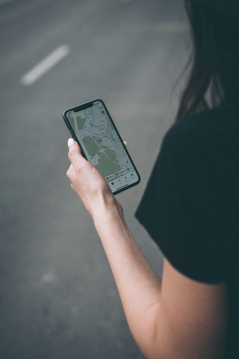 woman in black shirt holding black smartphone