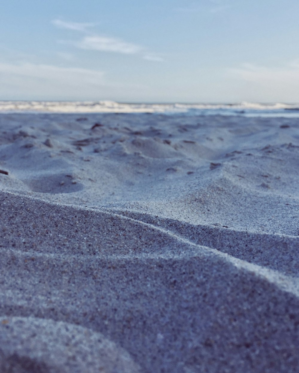 brown sand near body of water during daytime