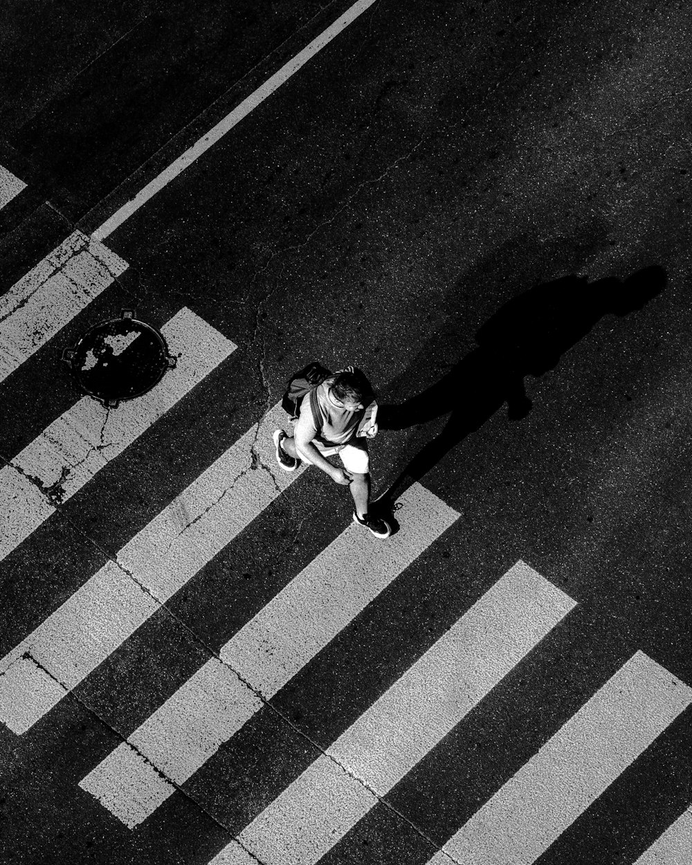 grayscale photo of a girl walking on a pedestrian line