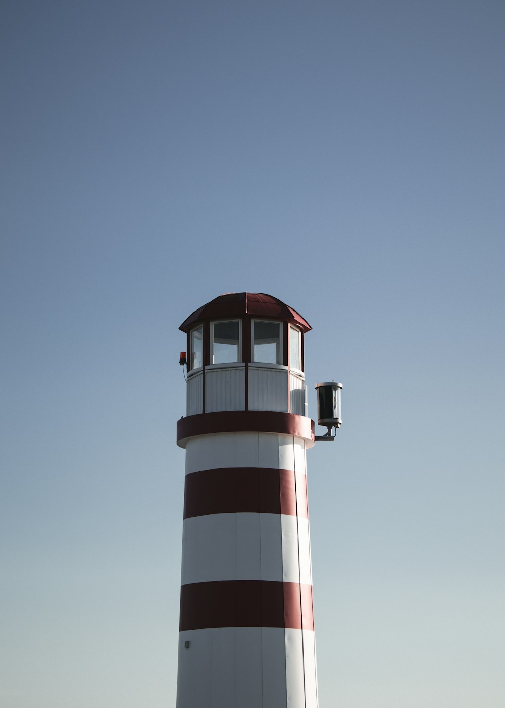 red and white striped lighthouse under blue sky during daytime