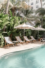 brown wooden folding chairs near swimming pool during daytime