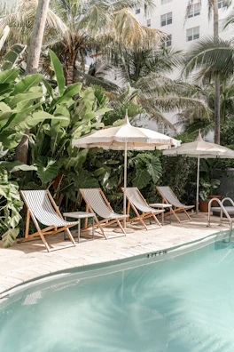brown wooden folding chairs near swimming pool during daytime