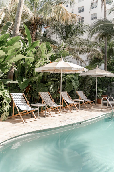 Resort-style pool deck with lounge chairs and palms