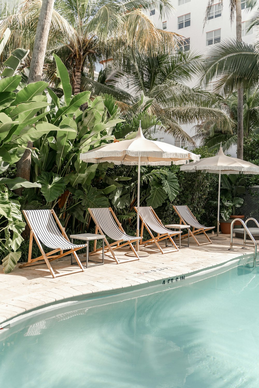 Chaises pliantes en bois marron près de la piscine pendant la journée