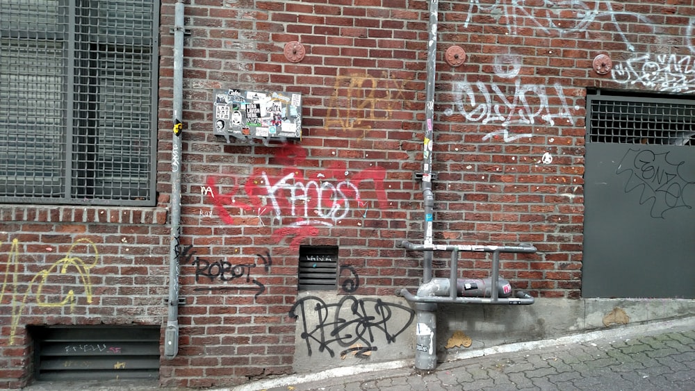 red and white brick wall with graffiti