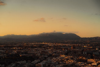 A vibrant book cover featuring a captivating cityscape at dusk with golden light reflections.