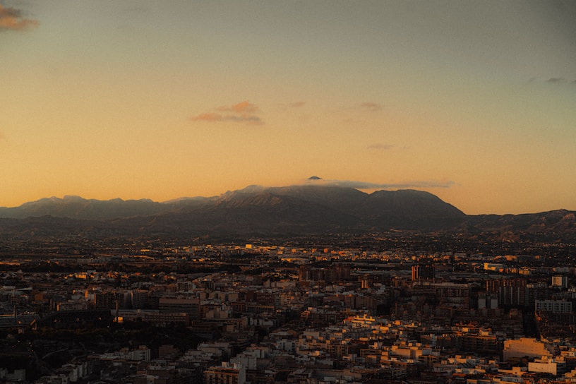 A vibrant book cover featuring a captivating cityscape at dusk with golden light reflections.