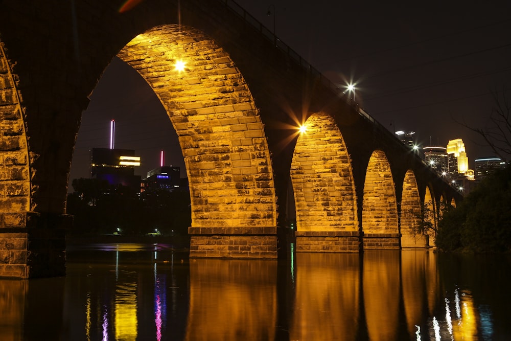 brown concrete bridge over water during night time