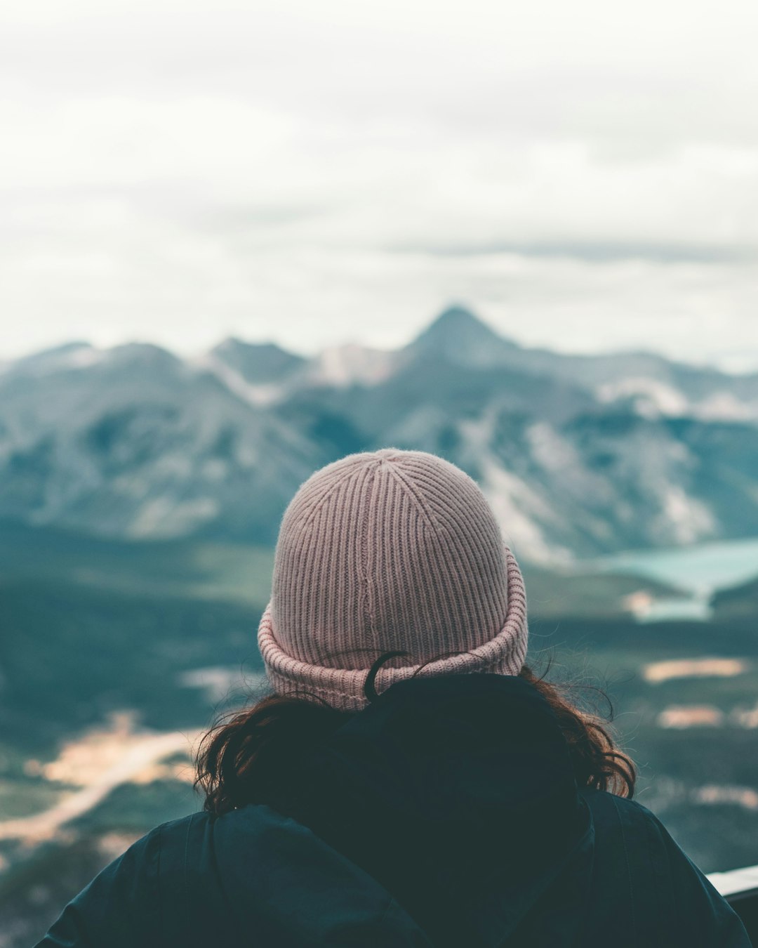 woman in white knit cap looking at mountains during daytime