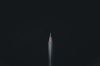 white and black pencil on black background