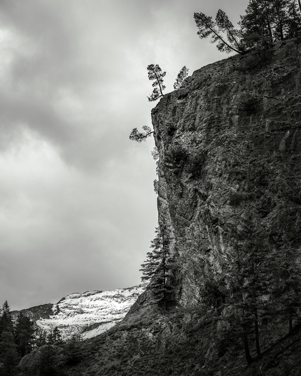 Foto en escala de grises de una persona que sube en la montaña
