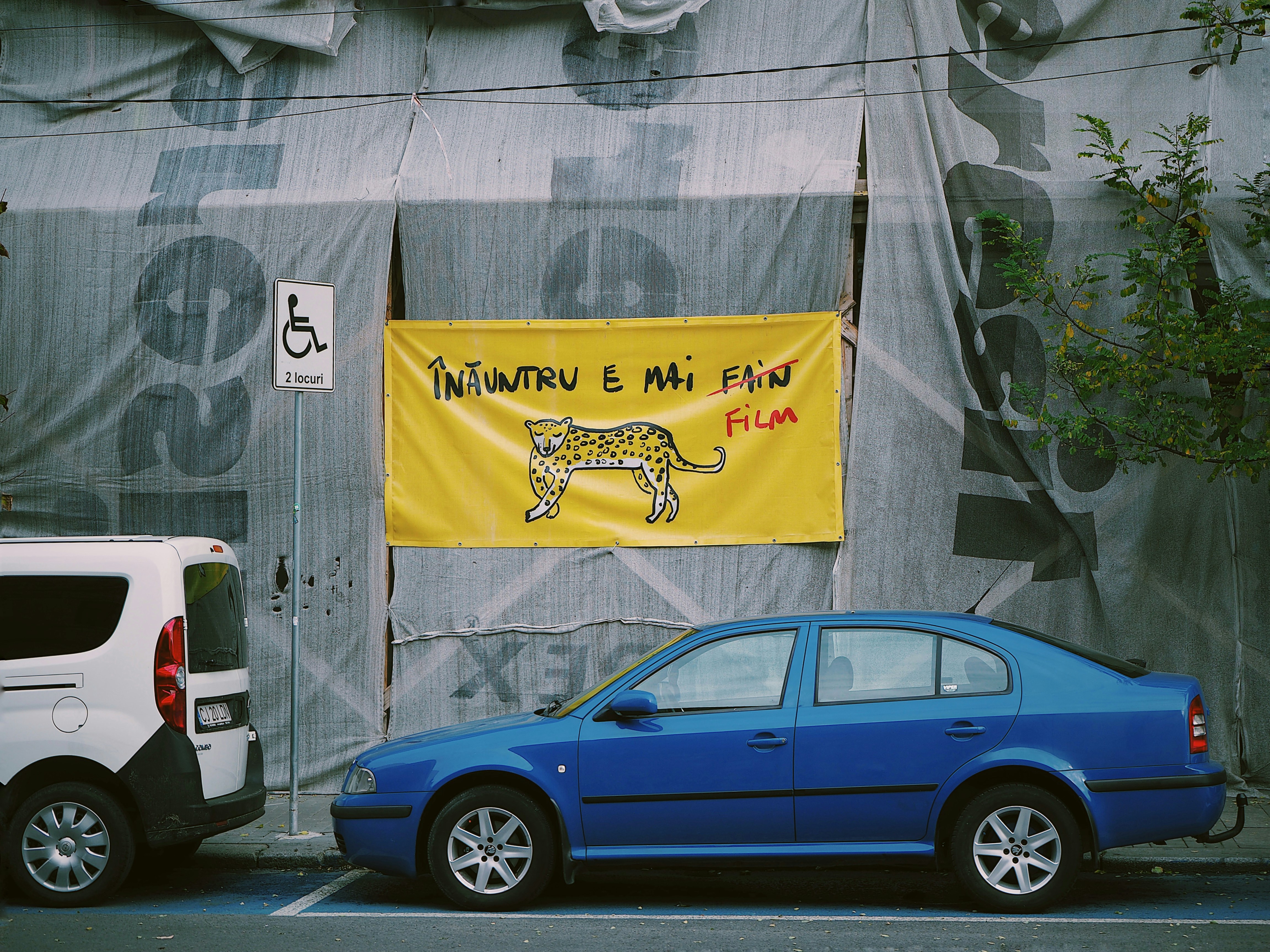 blue sedan parked beside white van