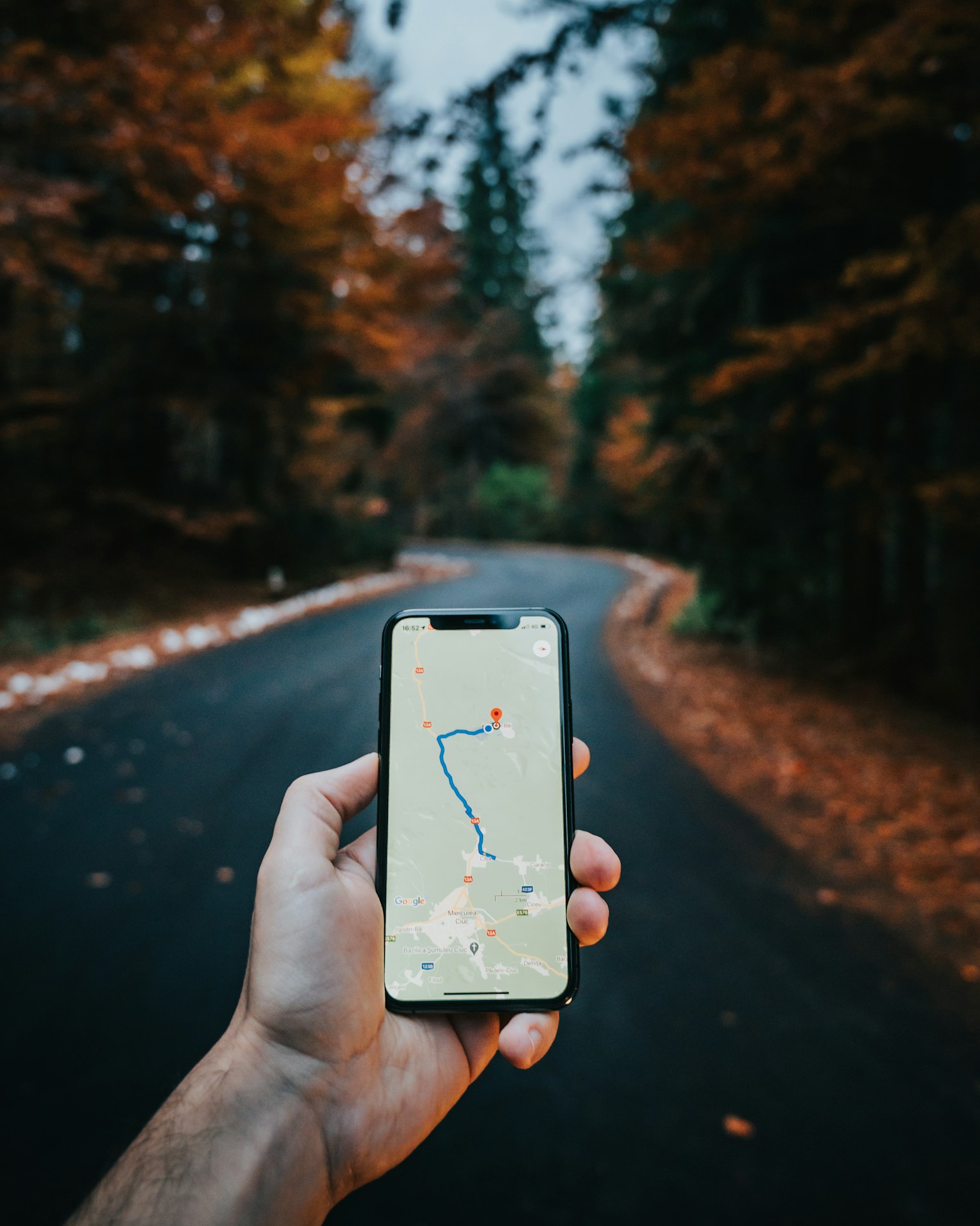 a person holding a cell phone with a map on it