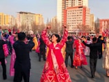 people in red and blue dress dancing on street during daytime