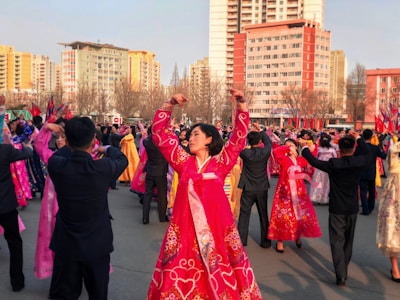 people in red and blue dress dancing on street during daytime