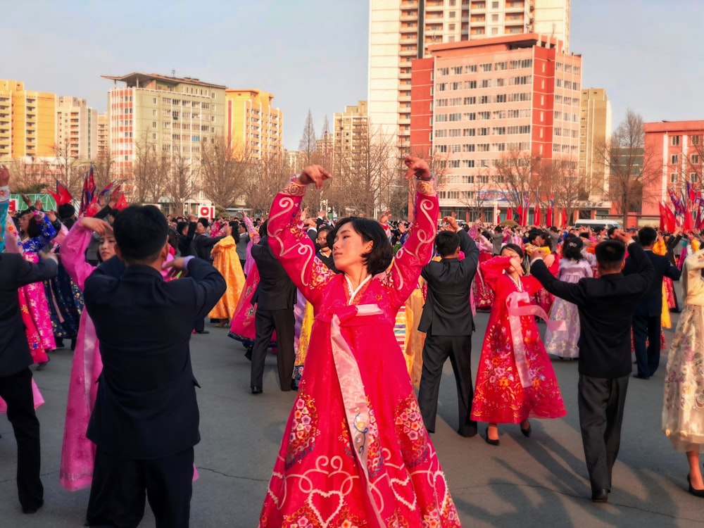 people in red and blue dress dancing on street during daytime