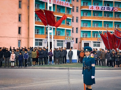 people walking on street during daytime north korea google meet background