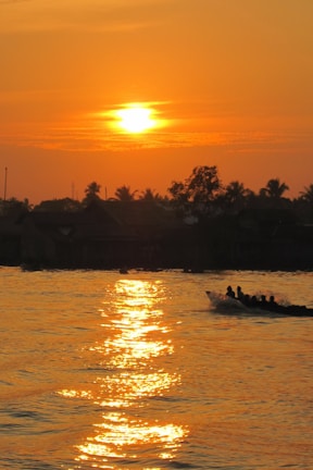 A vibrant group of travelers enjoying a sunset on a Kerala backwater boat.