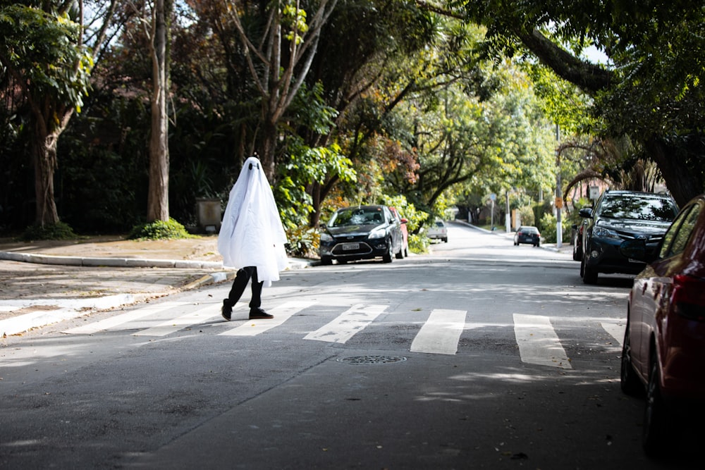 낮 동안 거리를 걷고 있는 하얀 드레스를 입은 여자