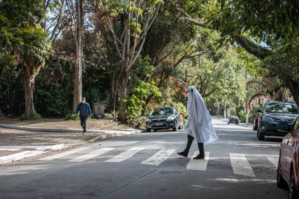 man in white thobe walking on the street during daytime