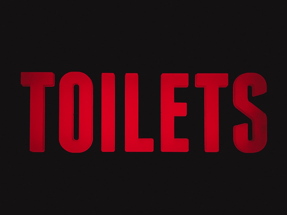 a red text that reads toilets on a black background