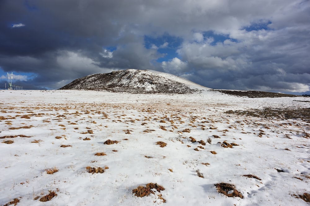 Montaña cubierta de nieve blanca bajo nubes blancas durante el día