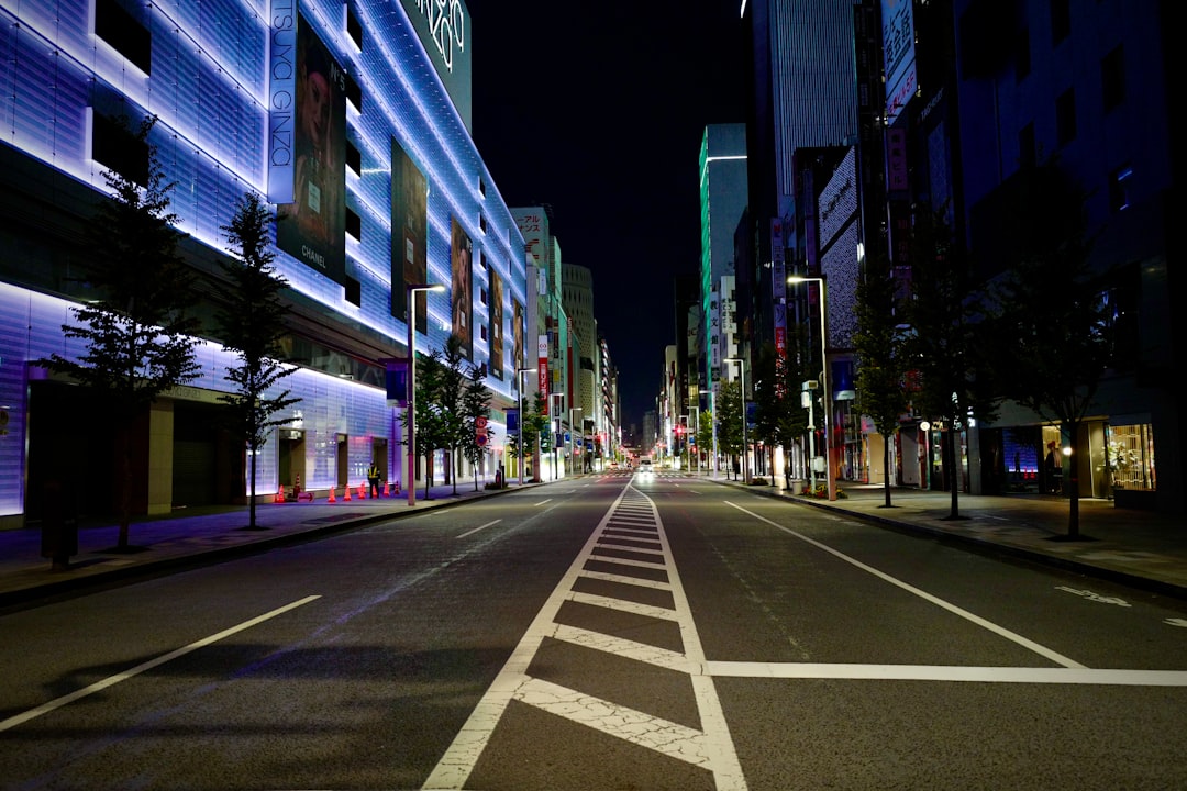 gray concrete road between high rise buildings during night time